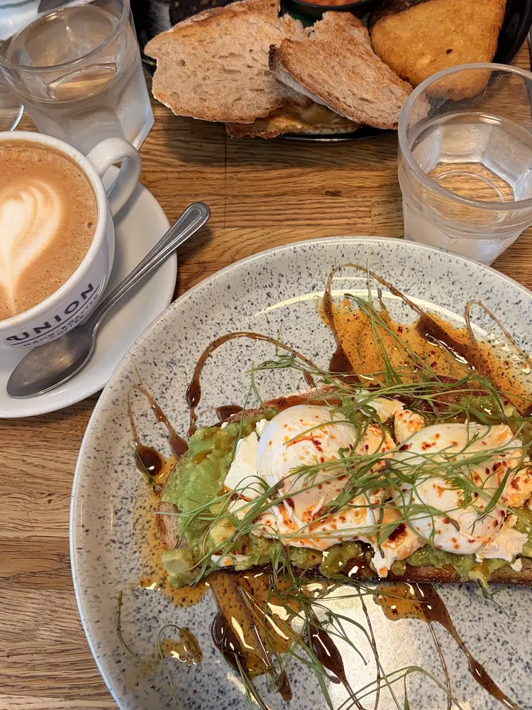 Avocado toast, full breakfast and flat white on a wooden table