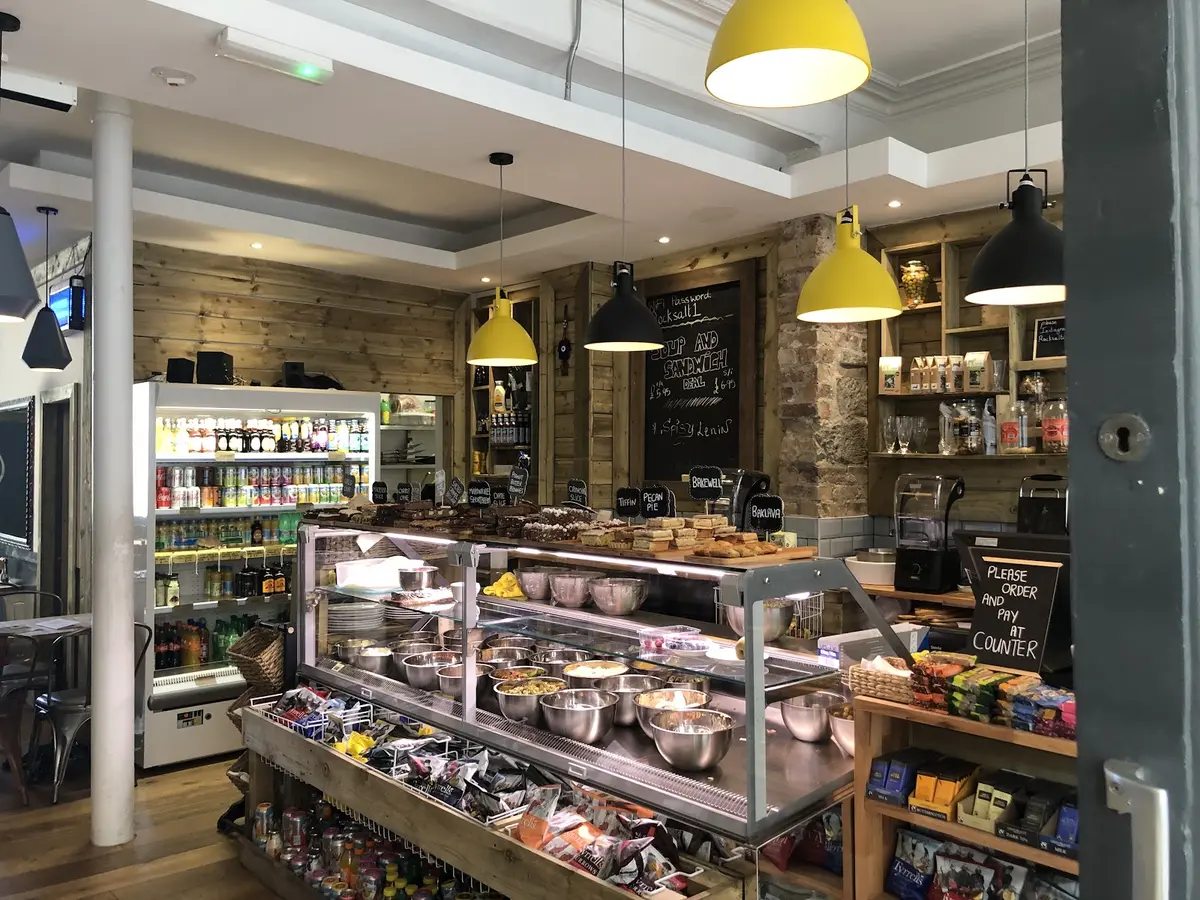 Rocksalt interior — deli counter, pastry display, yellow pendant lamps and timber walls